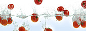 Tomatoes splashing in water