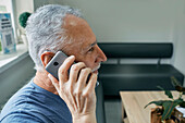 Man with hearing aid using mobile phone