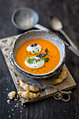 Tomato and carrot soup with goat's milk foam and small ham croissants (Alpine cuisine)