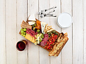 Antipasti platter with cheese, salami, vegetables, fruits, toasted bread, and crackers