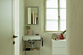 Helle Badezimmer mit verchromtem Waschtisch und Kommode
