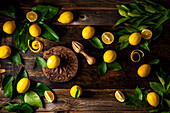 Meyer lemons with leaves on rustic wooden table