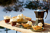 Apfelkuchen mit Kaffee auf Tisch im winterlichen Garten