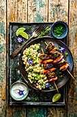 Beef and carrot skewers with creamy beans and leeks