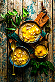 Vegan semolina pudding with turmeric mango ragout and almond slivers