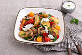 Warm potato salad with peppers, mushrooms, spinach, and tomatoes