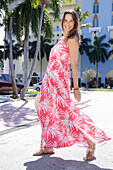 Brunette woman in long red and white printed summer dress