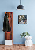 Teak wardrobe, painting, and light concrete stool in the hallway