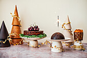 Früchtekuchen, Christmas Pudding und Pannetone dekoriert mit Tannenbäumchen aus Holz und Keramik