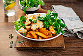 Cauliflower wings with potato wedges and lamb's lettuce
