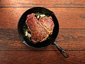 Porterhouse-Steak mit Knoblauch und Rosmarin in der Pfanne