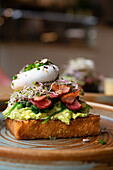 Sandwich with avocado, bacon and poached egg