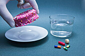 Diabetes medication next to a cake and glass of water