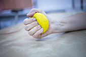 Patient squeezing physiotherapy ball