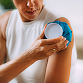Woman pressing cold compress to shoulder