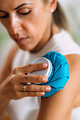 Woman holding cold press onto arm
