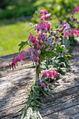 Tischdeko mit Tränendem Herz (Dicentra Spectabilis) und Storchschnabel (Geranium macrorrhizum), Kranz binden