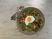 Spinach and strawberry salad with fried egg