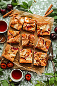 Sheet cake with apples and plums cut into squares