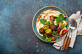 Arab meal with fried falafel, hummus, vegetables salad with fresh green cilantro and mint leaves (Middle Eastern)