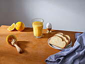Ein Glas frisch gepresster Orangensaft, Frühstücksei und einige Scheiben Brioche-Brot