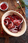 Herring marinated in red wine, with pomegranate seeds and red onion