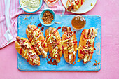 Hot Dogs mit Käse, Gurken-Senf-Sauce und knusprigen Zwiebeln