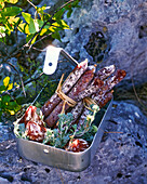 Assorted sausages in a baking tin for a picnic