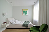 Weißes Doppelbett mit hohem Betthaupt in hellem Schlafzimmer