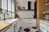Moderne, weiße Küche mit Holzelementen, sechseckige Fliesen auf dem Boden