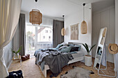 Double bed with pillow collection and woven pendant lights in bedroom