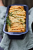 Loaf of pull apart rosemary bread in bread pan