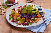 Colourful vegetable platter with pomegranate seeds and almonds