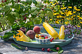 Gelbe und rote Himbeeren, Oregano, Zucchiniblüten, gelbe Zucchini und Pfirsiche aus dem Garten