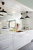 Elegant kitchen unit in white with mirrored wall