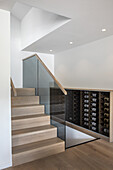 Weinschrank in elegantem Treppenhaus mit Holzstufen