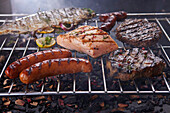 Grilled meat, sausage and fish on grill grate