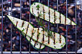 Grilled zucchini slices on grill grate