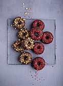 Donuts with chocolate icing, pistachios and freeze-dried strawberries