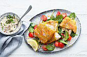 Whitefish baked on a spinach and tomato salad
