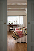 View through open sliding doors into the bedroom with exposed beams