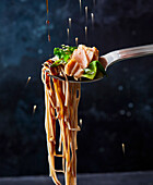 Soba noodles with teriyaki salmon on a fork