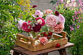 Bouquet of roses in vases on wooden tray
