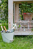 Wooden table with drinking bottles and strawberry plant in pot in front of it chilled champagne bottles in buckets