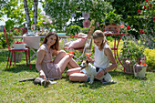 Two young women with their pets and drinks at a summer party in the garden