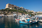 View across harbour to the historic citadel, colourful fishing boats in foreground, Bonifacio, Corse-du-Sud, Corsica, France, Mediterranean, Europe