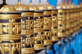 Rolling metal prayer wheels circling, with mantra written in Tibetan language, Shakhya Tharig Buddhist Monastery, Kathmandu, Nepal, Asia