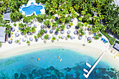 Kanus schwimmen in der tropischen Lagune eines Luxusresorts mit Swimmingpool am palmengesäumten Strand, Antigua, Westindien, Karibik, Mittelamerika