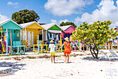 Mutter mit kleinem Jungen betrachtet die bunten Strandhütten, in denen Souvenirs verkauft werden, Antigua, Leeward-Inseln, Westindische Inseln, Karibik, Mittelamerika