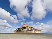 Mont Saint Michel, UNESCO-Weltkulturerbe, bei Ebbe mit blauem Himmel und Wolken, Normandie, Frankreich, Europa